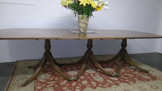 A Georgian style mahogany amp veneer triple-pedestal sectional dining table