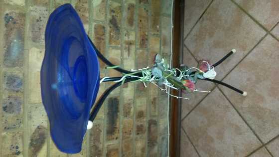 Blue glass bowl on stand with paper roses rapped around stand