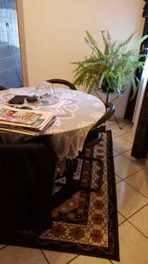 Glass round table with 4 black chairs and carpet