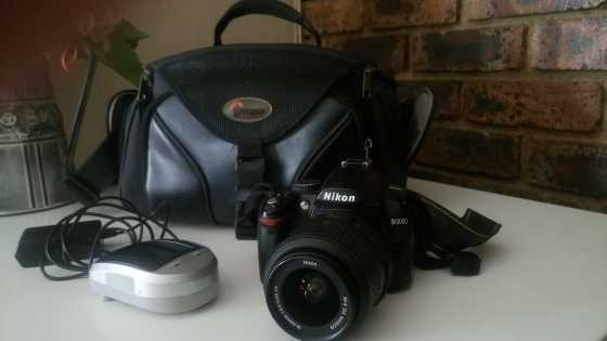 Nikon D3000 camera body, 18-55 Nikon lens (no lens cover), camera bag and SD card