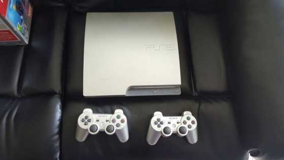 Silver 320GB Playstation 3, two dual shock controllers, eight games and DVD remote for sale